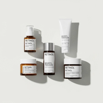 Skincare products with retinol and benzoyl peroxide on a clean background