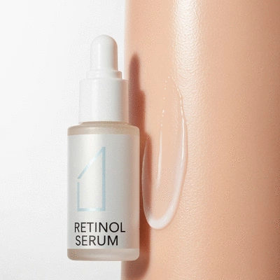 Close-up of a retinol serum bottle next to healthy skin, emphasizing smooth texture and hydration